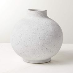 a white vase sitting on top of a table