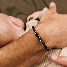 Introducing our exquisite custom black onyx beaded bracelet for men, set with stylishly crafted, beaded letters. This one-of-a-kind accessory showcases the perfect blend of sophistication and personalized style. Handcrafted with meticulous attention to detail, each black onyx bead is carefully selected to achieve a harmonious balance. The addition of the beaded letters adds a unique touch, allowing you to customize the bracelet with initials, meaningful words, or any desired combination. Perfect Black Round Bead Jewelry With Letter Details, Black Name Bracelet With Round Beads, Black Personalized Name Bracelet With Round Beads, Personalized Black Bracelets With Round Beads, Personalized Black Bracelet With Round Beads, Personalized Black Name Bracelet With Round Beads, Black Round Beads Wristband As Gift, Black Stretch Bracelet With Letter Beads And Round Beads, Personalized Black Beaded Bracelets, Adjustable