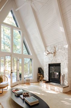 a living room with large windows and a fireplace