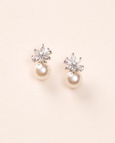 Feminine & floral with a dainty pearl accent, our Carmen Pearl Stud Earrings will be your new go-to pair. Perfect for brides & bridesmaids alike. Cubic zirconias & off white pearls Measures 0.75" Hypoallergenic, lead-free & nickel-free Style #4445 Formal Pearl White Flower Earrings With Pearl Drop, Elegant Silver Pearl Flower Earrings, Elegant Pearl Cluster Earrings For Party, Elegant Pearl White Flower Earrings For Formal Occasions, Elegant Pearl White Flower Earrings For Formal Events, Elegant Formal Pearl White Flower Earrings, Pearl Embellished Cubic Zirconia Wedding Earrings, Delicate Bridal Earrings With Pearl Charm For Party, Pearl White Cluster Earrings For Wedding