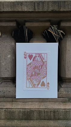 an ace playing card is on display in front of a stone wall