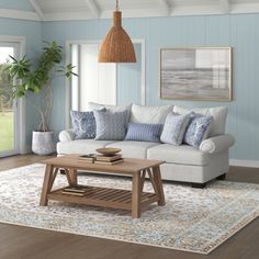 a living room with blue walls and white furniture