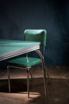 a green table and chair in a dark room