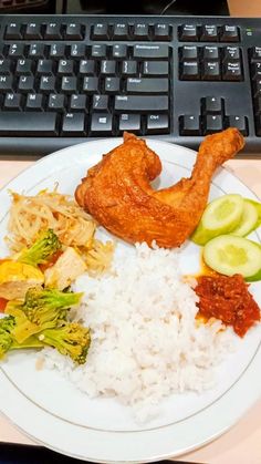 a white plate topped with rice and veggies next to a keyboard