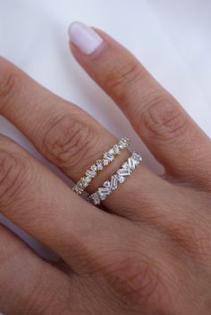 a woman's hand with two rings on it and one is wearing a diamond ring