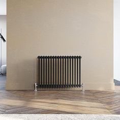 a radiator in the middle of a room with wood flooring and beige walls