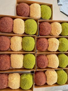 several boxes filled with different colored donuts on top of a table