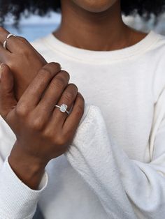 a close up of a person wearing a ring and holding something in her hand with both hands