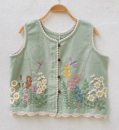 a green vest with flowers and butterflies on it