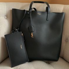 Authentic Black Leather Saint Laurent Purse. New-Never Used. Open At Top With Gold Tone Button Closure. Gold Tone Ysl Detail On Hanging Tassel. Attached Wallet/ Pouch Inside. Perfect Luxury Minimalist Bag. Smoke Free Home. Approximate Measurements: 15 In Across 14 In Tall, 10 Inch Hang On Handle. Plenty Of Room Inside. Easily Opens 14 In Across. Purchased From Saks-Faint Line Across Inside Tag. Saint Laurent Purse, Ysl Bags, Minimalist Bag, Bags Black, Wallet Pouch, Saint Laurent Bag, Leather Purse, 10 Inch, Ysl Bag