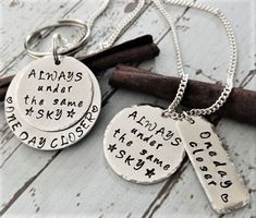 two silver necklaces with words on them