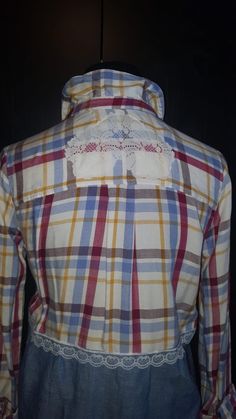 the back of a plaid shirt with lace on it