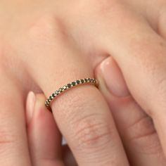 a woman's hand with a diamond ring on her left hand and the other hand holding it