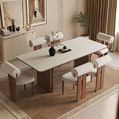 a dining room table with white chairs around it