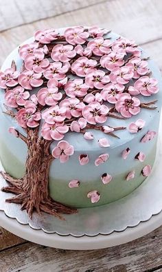 a cake decorated with pink flowers on top of a wooden table