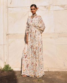 Introducing this mesmerizing printed full-length draped kaftan, where vibrant prints meet elegant detailing with an embellished neckline. This kaftan is the epitome of effortless style, offering both comfort and sophistication. Perfect for leisurely days or glamorous evenings, its flowing silhouette and intricate embellishments ensure you stand out with grace. Embrace luxury and make a statement with this exquisite kaftan that's sure to elevate your look wherever you go. Draped Kaftan, Embellished Neckline, Vibrant Prints, Effortless Style, Embellishments, Full Length, Quick Saves