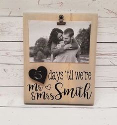 a wooden frame with a couple holding each other and the words days till we're mrs smith on it