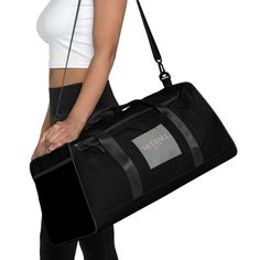 a woman carrying a black duffel bag with her hands on her hip and the bottom part of her body