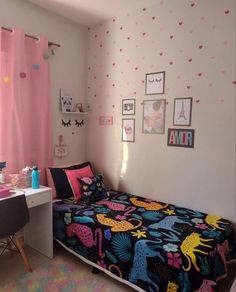 a bed room with a neatly made bed next to a desk and window covered in pink curtains