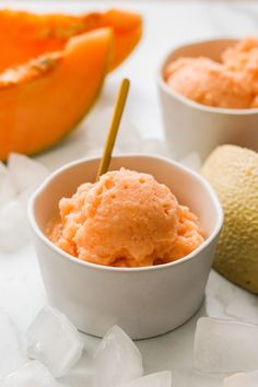 two bowls filled with ice cream next to sliced oranges