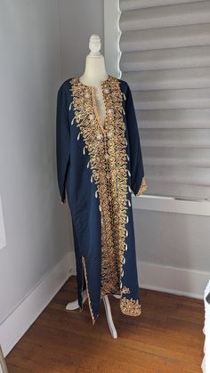 "Gorgeous Egyptian blue cotton women's formal kaftan dress Made in Egypt Embellished with peach colored trim, gold sequins, and faux pearls, all sewn on by hand. There is no size The dress measures 16\" across the top of the shoulders, 23\" sleeves, 23\" across flat between the armpits, 52\" long. Both slits on sides are 14\" long up from the hemline. It is in excellent condition and is truly a unique, handmade vintage item" Hand Embellished Gold Dresses For Eid, Gold Hand Embellished Dress For Eid, Bollywood Style Long Sleeve Dress With Pearl Embroidery, Bollywood Long Sleeve Dresses With Pearl Embroidery, Gold Kaftan For Party And Festivals, Elegant Dresses With Pearl Embroidery For Festivals, Gold Kaftan With Dabka Work For Party, Gold Embellished Kurta For Party, Gold Dresses With Dabka Work