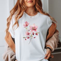 Introducing our delightful Floral Harmony t-shirt, featuring a trio of charming flowers in pink, yellow, and purple hues, set against a crisp white background.   Embrace the beauty of nature with this vibrant design, perfect for adding a burst of color to your wardrobe. Crafted from premium-quality cotton, it offers a comfortable fit for all-day wear. Available in different sizes, please refer to our size guide for the perfect fit. Whether you're exploring the city streets or relaxing in the gar Feminine Cotton Short Sleeve T-shirt, Pink Graphic Tee With Plant Print, Pink Graphic Tee With Plants Print, White Cotton T-shirt With Rose Print, Spring Rose Print Short Sleeve T-shirt, Spring Cotton T-shirt With Rose Print, Pink Cotton T-shirt With Plant Print, Spring Pink T-shirt With Plant Print, Pink T-shirt With Plant Print, Short Sleeve