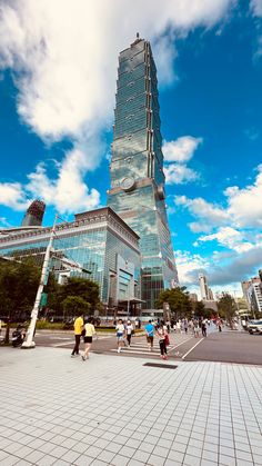 people are walking around in front of a tall building