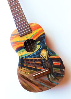 a guitar with a painting on it sitting next to a wall