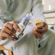 a person sitting down holding a bottle of clean