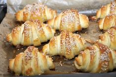 many croissants are lined up on a baking sheet and ready to be baked