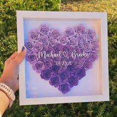 a person holding up a paper heart with the words michael and brooke on it in front of some bushes