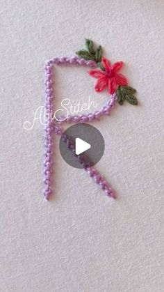 the video is showing how to make beaded letters with beads and flowers on them