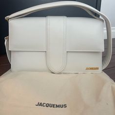 Brand New Only Used Once Large Size White Jacquemus Bag 7.9” H 13.8” W 7.9” D Timeless Rectangular Flap Bag With Dust Bag, Designer White Rectangular Flap Bag, Classic Tote Baguette Bag With Dust Bag, Classic Leather Tote Baguette Bag, High-end White Box Bag With Gold-tone Hardware, Designer White Baguette Bag, High-end White Flap Bag For Evening, High-end White Shoulder Flap Bag, White High-end Evening Flap Bag