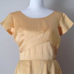 Vintage 1940's Old Hollywood formal satin dress or gownThis dress is a nice, heavy satin in a pale gold colorInteresting bodice designThe skirt is very full with large, hidden pleatsShort sleevesMetal, back zipperFitted bodice with bust dartsRound neckline in front and a V in the back.The dress has a smaller waist than the mannequin. Please note that the back view does not have the dress zipped up all the way.Label: NoneSize: Please see measurementsSatinMeasurements: taken with garment flat17 1/ Gold Satin Finish Dress For Wedding, Gold Silk Dress With Fitted Bodice, Formal Cream Fitted Satin Dress, Formal Fitted Cream Satin Dress, Cream Fitted Satin Dress For Formal Occasions, Gold Bias Cut Dress For Formal Occasions, Fitted Gold Dress With Satin Finish, Gold Satin Finish Fitted Dress, Yellow Vintage Silk Dresses