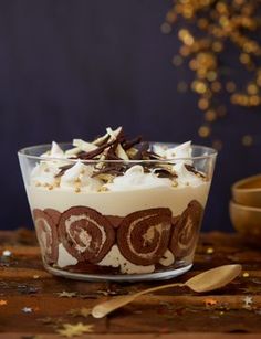 a dessert in a glass bowl with chocolate and white frosting on top, topped with sprinkles