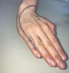 a person's hand with a small tattoo on the middle of their left arm