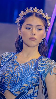 a woman wearing a blue dress and headpiece