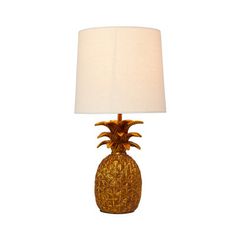 a gold pineapple lamp with a white shade