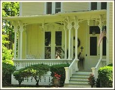 a yellow house with white trim and columns