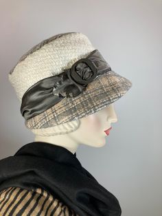 "Callie" is a soft plaid wool and boucle fabric hat. She is perfect for chilly weather and will keep you cozy warm (and stylish!) this winter. The top and brim of the hat is a pretty plaid in gray, white and beige. The side crown is an ivory boucle fabric with a bit of gold mylar sparkle that started life as an unworn skirt. It's topped with a water marked gray metallic ribbon laced through a vintage carved plastic buckle. It has an asymmetrical 1920s small brim and is easily packed for travel. Fitted Beige Cloche Hat, Beige Cloche Hat With Curved Brim For Fall, Cream Fedora Hat For Winter, Cream Fedora Winter Hat, Elegant Winter Cloche Hat, Adjustable Beige Cloche Hat For Fall, Adjustable Beige Bucket Hat For Fall, Vintage Beige Cloche Hat For Winter, Beige Cloche Hats For Fall