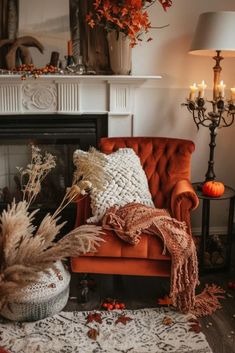 an orange chair sitting in front of a fire place filled with candles and fall decorations