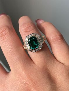 Vintage Art Deco 3.21 CT Green Emerald Cut Ring|Classic Bridal Ring|Emerald Halo Ring|Accent Baguettes|Side Trapezoid|14k Solid Gold Jewelry ❤ ITEM DETAILS:- ✦ Brand: The American Gold House (TAGH) ✦ Handmade, high-quality item! ✦ Material: Solid 10K/14K/18K Gold, 950 Platinum and 925 Sterling Silver ✦ Diamond Type: Moissanite Diamond ✦ Diamond Cut: 9.5x7.5 MM Emerald ✦ Diamond Color: Deep Green Emerald (Lab Created) ✦ Diamond Clarity: VVS/VS ✦ Center Diamond: 9.5x7.5 MM 3.21 CT Emerald ✦ Width of Band: 4.0 MM (Bottom)                                                                                                                                                                          ❤ ACCENT/HALO DIAMONDS:- ✦ Side Stone Material: Moissanite Diamond ✦ Side Stone Shape: Baguette & Trapezoi Gia Certified Oval Emerald Ring In Art Deco Style, 14k Gold Emerald Cut Art Deco Ring, 14k Gold Octagon Emerald Ring, Gia Certified Baguette Cut Emerald Ring In 14k Gold, Heirloom Emerald Ring Baguette Cut, Heirloom Style Baguette Cut Emerald Ring, Heirloom Baguette Cut Emerald Ring, Classic Green Emerald Ring With Baguette Diamonds, Formal 14k Gold Green Emerald Ring