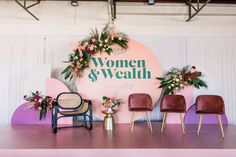 a stage set up for a women's health event with chairs and flowers on it