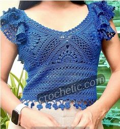 a woman wearing a blue crochet top with flowers on it