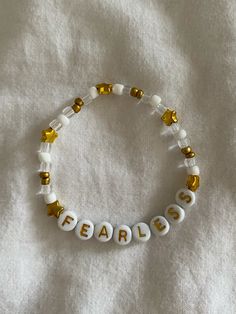 a beaded bracelet with the word fearless written in gold and white letters on it