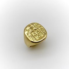 This 18k gold Tiffany & Co. Larter & Sons signet ring is hand carved with a heraldic family crest. The crest has a shield with three bell-like shapes sprouting flowers. Above the shield is a knight’s helmet topped with a feather and surrounded by scrolling foliate. The classic design of the crest suggests royalty and valor.  Larter & Sons was founded in 1865 and was renowned for their exquisite craftsmanship of men’s accessories. They expanded to include women’s jewelry in the early 20th century, using intricate techniques such as guilloche and enamelwork, and incorporating motifs inspired by nature. They collaborated with Tiffany & Co. to make jewelry such as cufflinks and signet rings. Tiffany & Co. would often consign well-known brands of the highest quality, including Larter & Sons. Gold Tiffany, Vintage Tiffany, Signet Rings, Gold Signet Ring, Family Crest, Fantasy Fashion, Signet Ring, Tiffany & Co., Classic Design