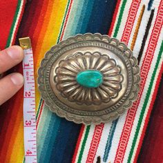 "This piece is a beautiful oval belt buckle with scalloped edges and 1 large cabochon natural turquoise handset in the center. Great gift for an anniversary, birthday or an amazing wedding suit addition for a southwestern vibe. 56 grams for the entire piece 3\" long 3.4\" wide 1\" thick including buckle Signed by artist Ray Adakai. If you have questions about this item etc please ask before you purchase. Sold as-is, no returns or exchanges on any jewelry. Free domestic shipping Thanks for lookin Oval Concho Jewelry Gift, Handmade Artisan Silver Belt Buckles, Antique Concho Jewelry For Gifts, Western Style Oval Concho Jewelry, Antique Concho Jewelry As Gift, Antique Concho Jewelry For Gift, Antique Concho Jewelry As A Gift, Artisan Oval Concho Jewelry, Western Oval Engraved Jewelry