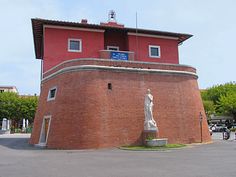 a red building with a statue in front of it