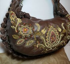 Elegant Brown Bags With Tassels, Luxury Brown Shoulder Bag With Tassels, Elegant Brown Shoulder Bag With Tassels, Designer Bags With Tassels, Brown Embellished Luxury Bag, Formal Embroidered Leather Shoulder Bag, Luxury Brown Embellished Bags, Luxury Embellished Brown Bag, Brown Embroidered Hobo Shoulder Bag