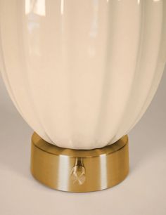 a white and gold table lamp on a metal base